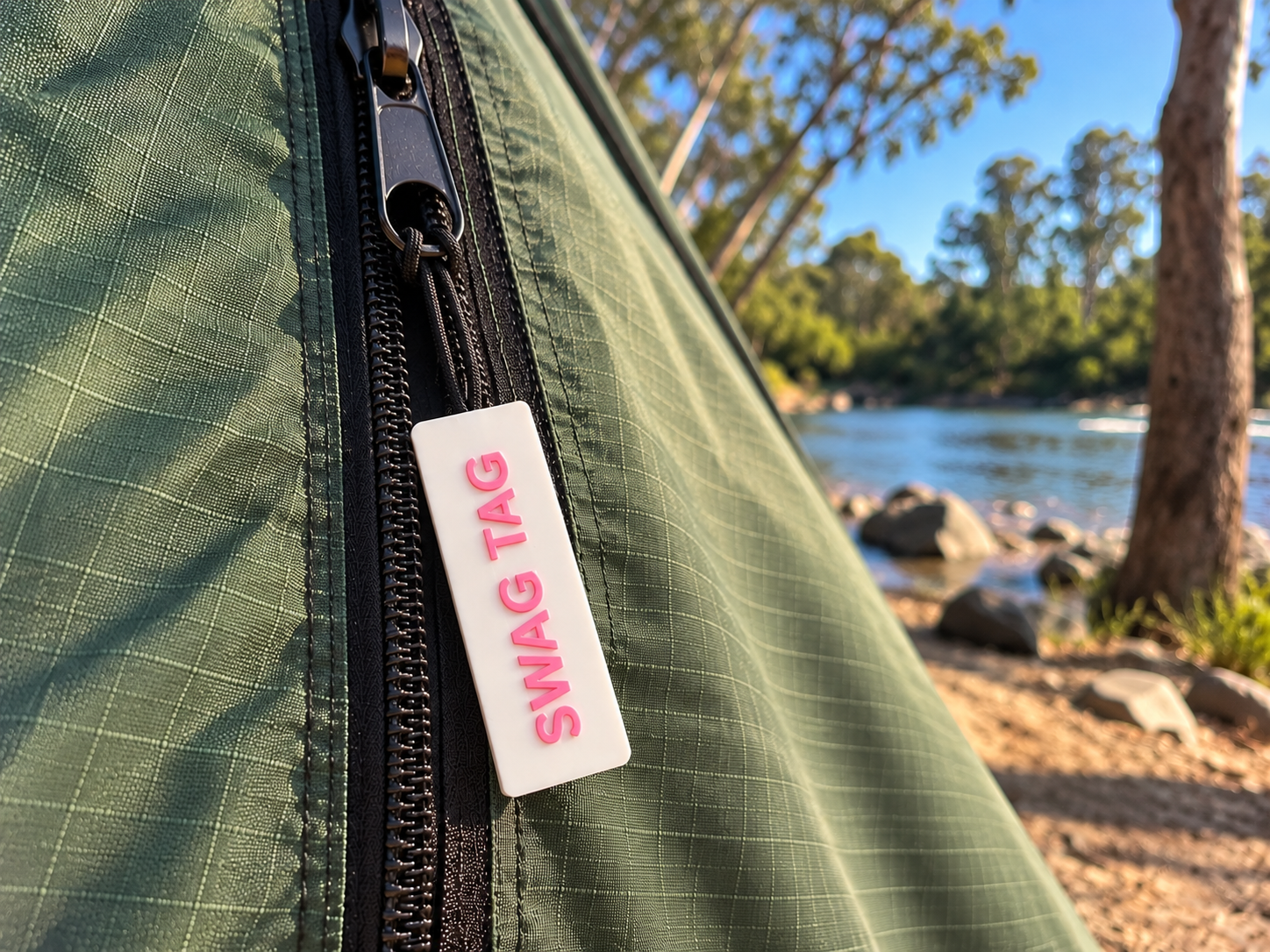 SwagTag on tent zipper by the river at dusk