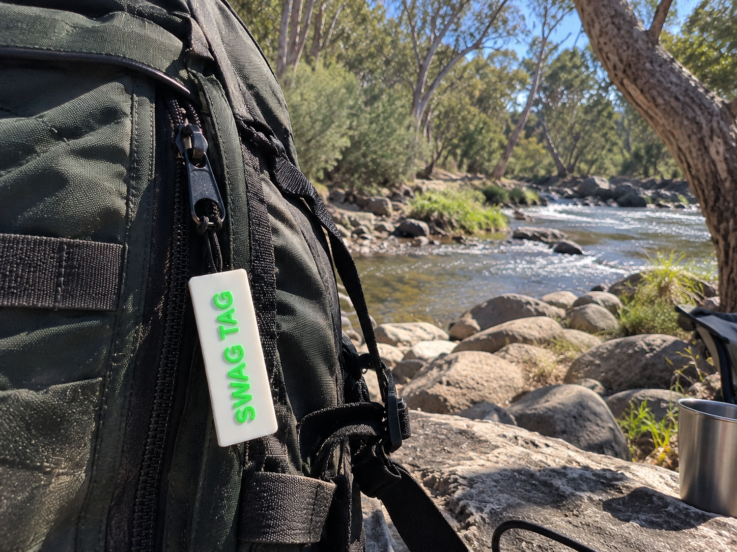 SwagTag on backpack by a rocky river